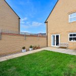 Back garden with patio and plants.