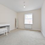 Minimalist empty room with desk and window.