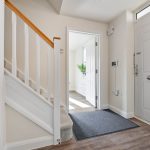 Modern hallway with staircase and open door.