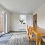 Modern dining room with wooden table and chairs.