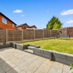 Fenced garden with patio and swing.