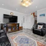 Modern living room with TV and leather sofas.