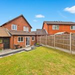 Back garden with brick house and fence