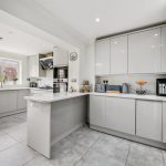 Modern white kitchen with appliances and island.