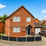Brick house with driveway and car.