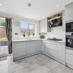 Modern kitchen with garden access and grey cabinets.
