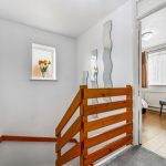 Staircase with wall mirrors and window view.