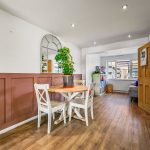Bright dining area with plant and wooden furniture.