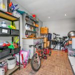 Garage with bicycles, toys, and storage shelves.