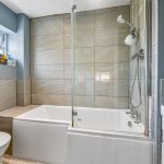 Modern bathroom with bathtub, shower and window.