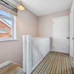 Bright hallway with window and striped carpet