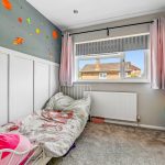 Children's bedroom with colourful space-themed wall decor.