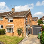 Semi-detached brick house with driveway and garden.