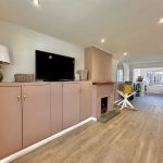Modern living room with TV and wooden flooring.