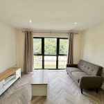 Modern living room with sofa and large window view.
