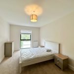 Bright minimalist bedroom with bed and drawers.