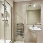 Modern bathroom with shower, sink, and mirror.