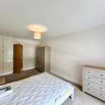 Minimalist bedroom with wardrobe and dresser.
