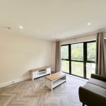 Bright living room with large window and modern furniture.