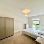 Minimalist bedroom with wardrobe, chest, and bed.