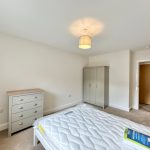 Minimalist bedroom with wardrobe and chest of drawers.