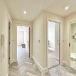 Bright hallway with three open doors.