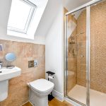 Modern bathroom with shower, sink, and toilet.