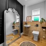 Elegant bathroom with large mirror and modern fixtures.