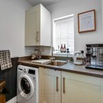 Modern laundry room with appliances and storage.