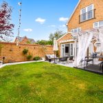 Modern garden patio with Buddha statue and seating area.