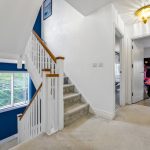Modern home staircase with carpet and hallway view.