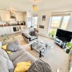 Modern open-plan living room with kitchen area.