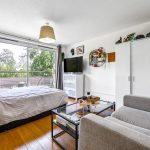 Spacious bedroom with balcony view and modern decor.