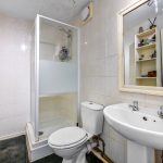 Small bathroom with shower, toilet, and sink.