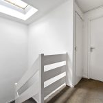 Stairway with skylight and white walls