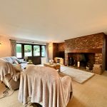 Spacious living room with brick fireplace and cosy seating.