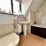 Modern bathroom with bathtub, sink, and toilet.