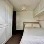 Small bedroom with white wardrobe and single bed.