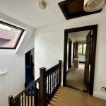 Upstairs hallway with window and open door.