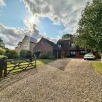 Suburban house with gravel driveway and parked car