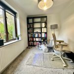 Cosy home office with chair and bookshelves.