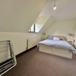 Loft bedroom with bed and skylight.