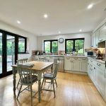 Spacious modern kitchen with wooden dining table.