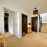 Modern hallway with wooden staircase and furniture