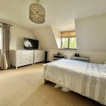 Spacious bedroom with double bed and TV.