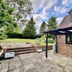 Brick house with garden and patio view.