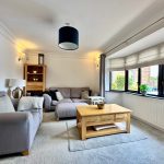 Bright living room with cosy grey sofas.