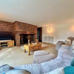 Cosy living room with brick fireplace and sofas.