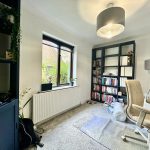 Cosy home office with bookshelves and ergonomic chair.