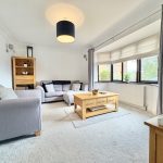 Bright living room with grey sofas and wooden furniture.